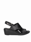 Sandalia negra de cuero premium para mujer, diseño anatómico y taco cuña que estiliza la figura.