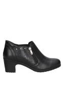Elegante botín casual de cuero negro para mujer, con remaches metálicos decorativos y estilo urbano sofisticado.