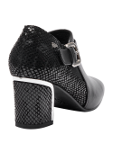 Botín negro de cuero para mujer, diseño moderno con tacón medio y hebilla lateral, ideal para un look casual.