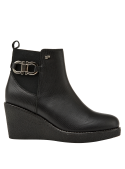 Botín chelsea negro de mujer en cuero con suela de cuña, estilo casual y urbano, con detalle metálico decorativo.