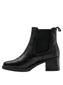 Versátil botín negro de cuero para mujer, estilo Chelsea, sin elementos decorativos, combina con jeans o faldas midi.