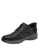 Calzado masculino casual en cuero negro, con suela gruesa para amortiguación y soporte en caminatas largas.