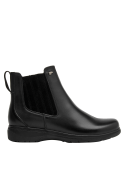 Botín Chelsea negro para mujer, elegante y sofisticado, con líneas limpias y detalle metálico en el costado superior.
