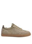 Zapatilla taupe de cuero para mujer, diseño clásico y urbano con suela plana, adecuada para diversas ocasiones casuales.