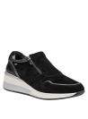 Zapatilla para mujer en cuero negro, estilo casual, con detalles contrastantes en el talón y suela elevada.