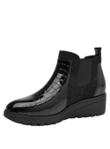 Botín Chelsea negro en cuero charol con textura reptil, paneles elásticos y lengüeta en el talón para fácil calce.