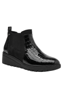 Botín Chelsea negro de mujer, cuero charol reptil, paneles elásticos y suela gruesa de plataforma.