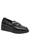 Calzado de cuero negro tipo mocasín, suela gruesa y estable, versátil para diversas combinaciones y estilos.