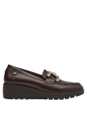 Zapato marrón de cuero estilo mocasín, detalle metálico decorativo, versátil para atuendos formales e informales.