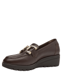 Calzado de cuero marrón estilo mocasín para mujer, con suela gruesa y plataforma que proporciona estabilidad y altura cómoda.