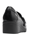 Zapato de mujer en charol negro, diseño mocasín con hebilla, cuero lustroso, suela plataforma para altura y seguridad.