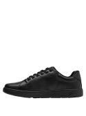 Calzado urbano negro de cuero suave, diseño versátil con lengüeta acolchada y ojales metálicos modernos.