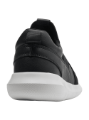 zapatilla negra urbana de cuero con suela gruesa que ofrece buena amortiguación, ideal para uso casual y actividades físicas.