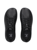 Zapatilla urbana negra de cuero, corte bajo para libertad de movimiento, con detalles industriales y ajuste personalizado.