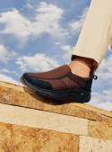 Zapatilla marrón de cuero estilo mocasín urbano para hombre, sin cordones, material gamuza elegante y casual.