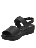 Sandalia de cuero negro para mujer con hebilla metálica grande y suela de plataforma baja.