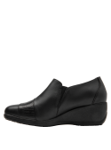 Elegante zapato negro de cuero para mujer con suela cuña, ideal para uso diario.