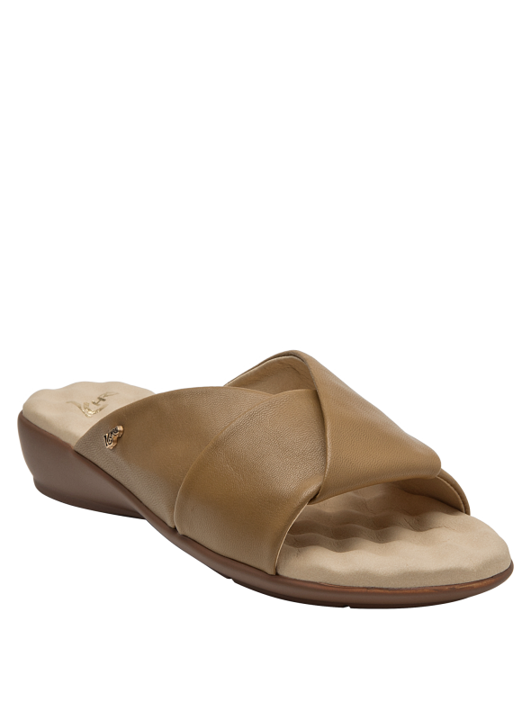 Calzado casual de mujer en cuero camel, con estructura cruzada y detalle dorado distintivo.