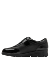 Elegante zapato de mujer en cuero negro charol, con insignia lateral decorativa.