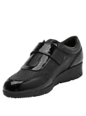 Zapato de cuero negro charol, diseño moderno y funcional con cierre de velcro para mujer.