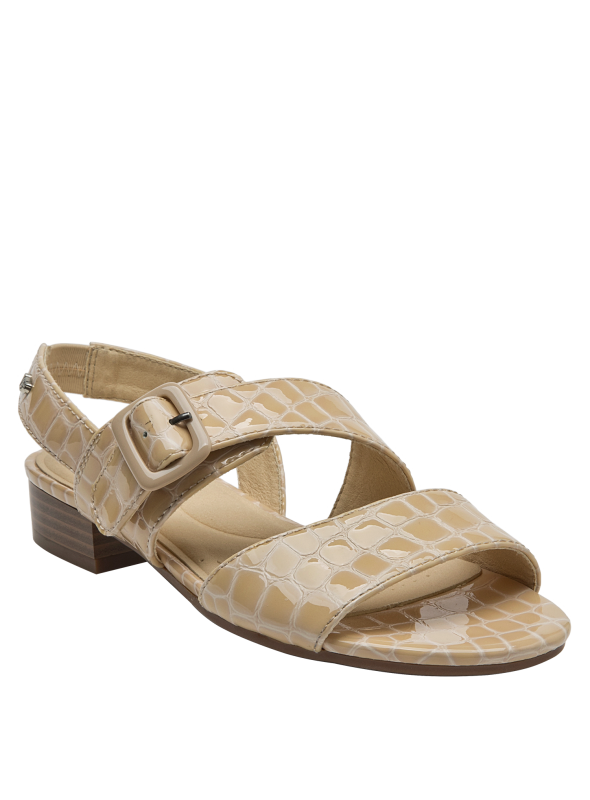 Vista del lado de la sandalia de cuero beige con suela a juego y hebilla ajustable.