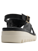 Calzado casual chic de cuero negro con diseño moderno y textura granulada.