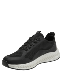 Zapatilla negra deportiva de mujer con exterior textil y detalles de malla para ventilación.