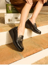 Mocasín negro de cuero para mujer con diseño slip-on y punta redonda.