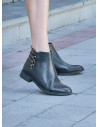 Botín de cuero negro para mujer, estilo casual, ideal para actividades diarias.