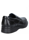 Zapato de hombre negro de cuero, estilo vestir, diseño mocasín sin cordones con costuras discretas y punta redondeada.